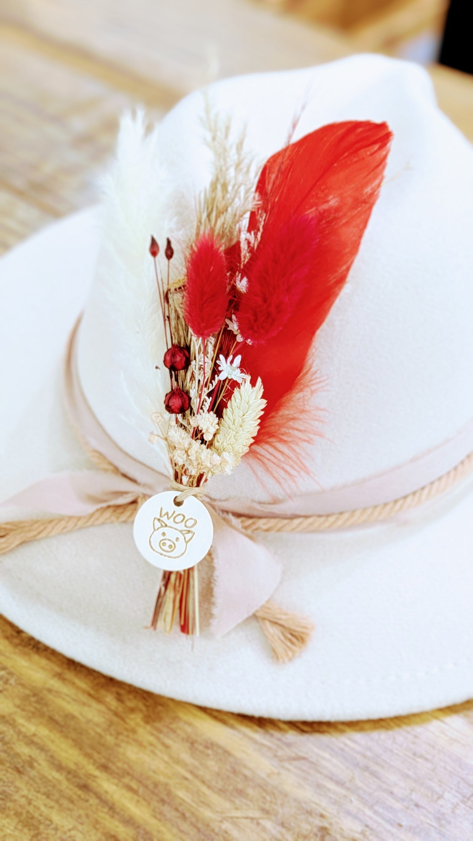 arkansas razorback themed floral hat pin with dried florals, feathers, and grass