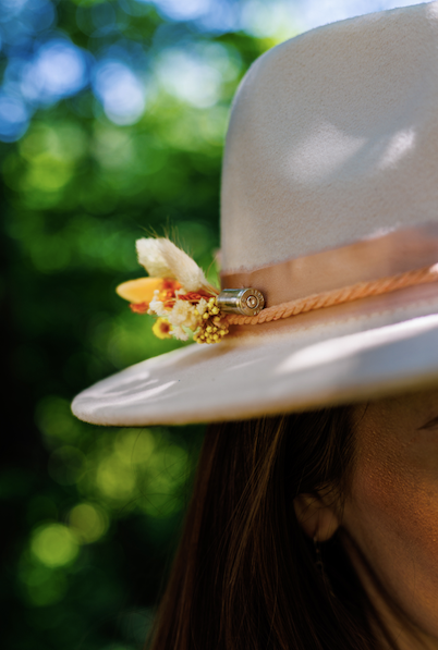 White hat with floral decoration against a blurred green background