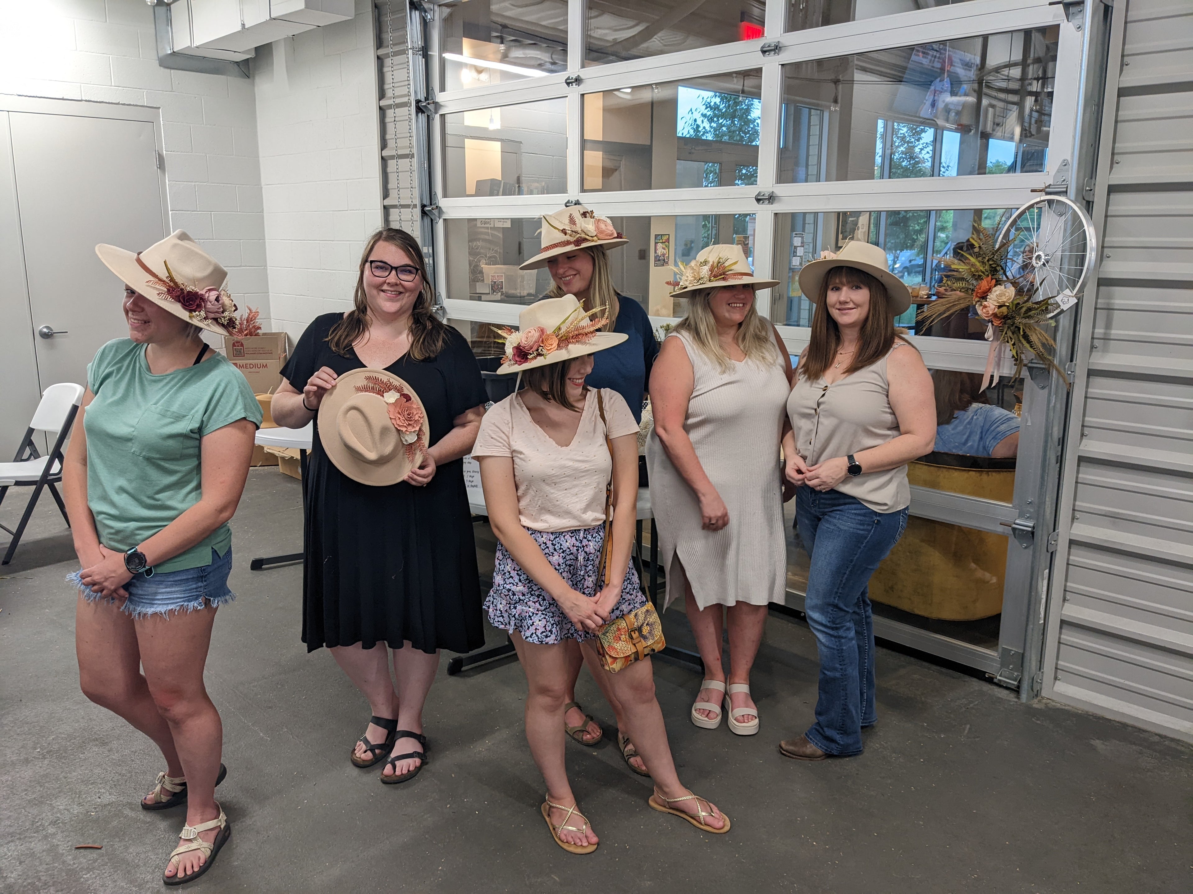 Group of women wearing hats indoors, with a storage unit in the background