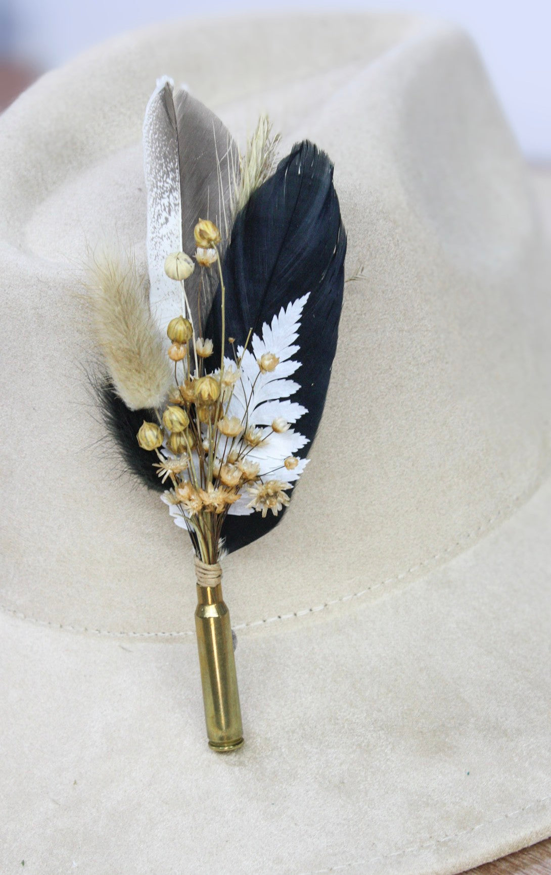 Bullet BrimBud hat pin Tuxedo with black feather, white fern, and gold berries on a cream felt hat