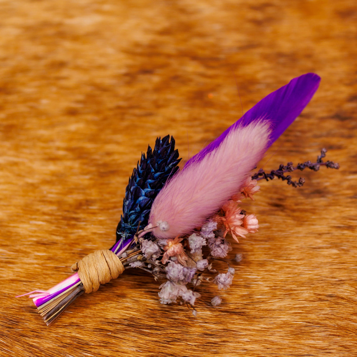 BittyBud hat pin with a purple feather, pink bunny tail, navy dried grass, and peach and lavender florals